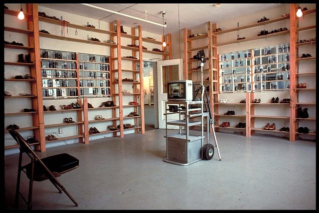 Seyed Alavi
Departure Room, 1989
shoes, shelves, photo transparency, water, video monitor, camera, chair, motion detector, lights, 240 x 300 x 120 in.