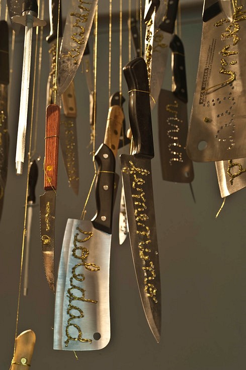 Catalina Mena
Domestic Lexicon (detail), 2012
different kinds of used kitchen knives hand-embroidered with gold thread suspended from the ceiling by the  same gold thread and metal nails, 200 x 200 x 480 cm